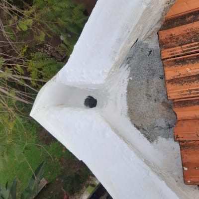 רעפים כתומים על גג עם טיח לבן