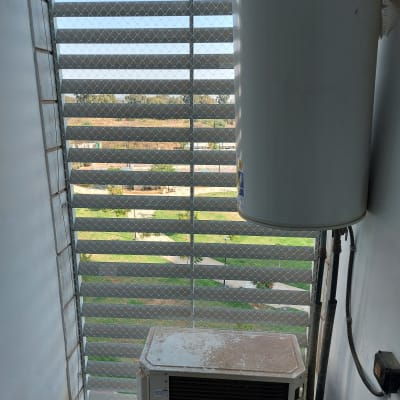 רשת מתכת על חלון למניעת כניסת יונים