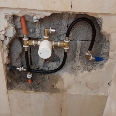צנרת מים חשופה בקיר במהלך שיפוץ
