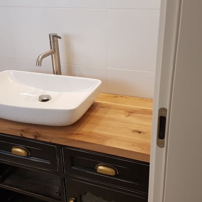 כיור לבן עם ברז מתכת על משטח עץ