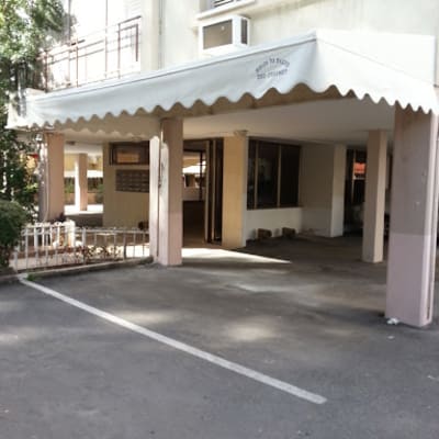 סוכך לבן עם קצוות משוננים מעל כניסה לבניין