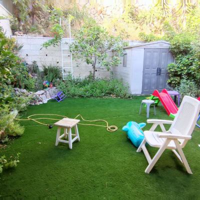 צינור השקיה על דשא מלאכותי בגינה