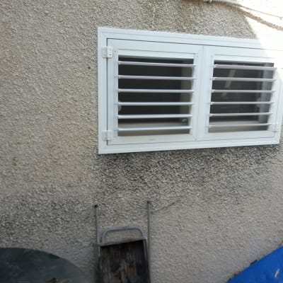 חלון אלומיניום עם תריסים על קיר חיצוני