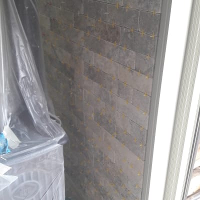 קיר עם אריחים חדשים ומרווחים, מכוסה בניילון