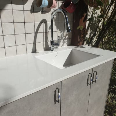 שיש לבן עם כיור וברז במטבח חיצוני