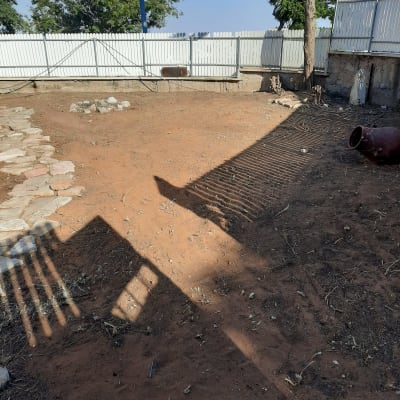 אדמה חשופה עם אבנים ועציץ חרס לגינון