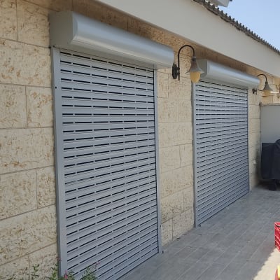 תריסי אלומיניום סגורים על קיר אבן חיצוני