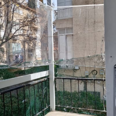 רשת בטיחות מותקנת על מרפסת עם מעקה ברזל
