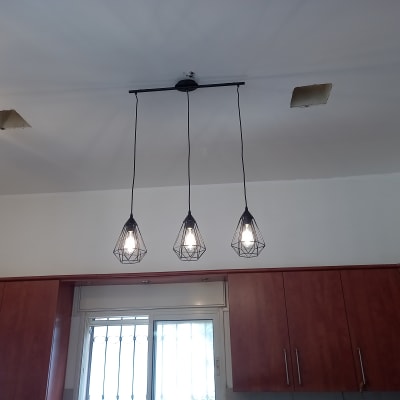 שלושה מנורות תלויות מהתקרה עם נורות דולקות