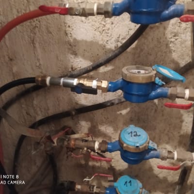 מד מים כחול עם ברזים אדומים וצינורות