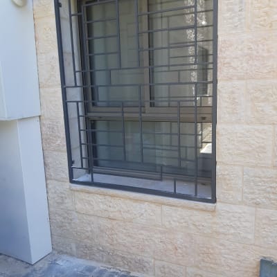 חלון עם סורגי מתכת בעיצוב גיאומטרי