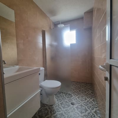 חדר אמבטיה עם אריחים חדשים, מקלחון ושירותים