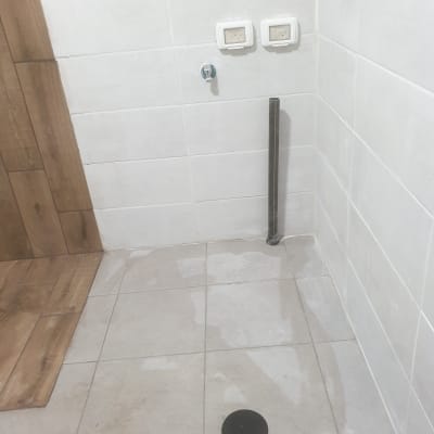 קיר עם אריחים, שקעי חשמל וצינור חשוף