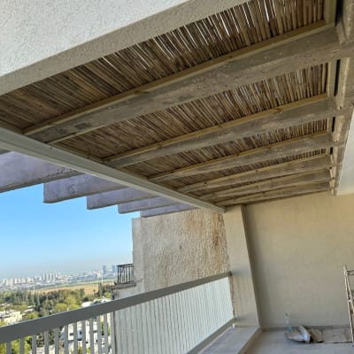 פרגולה מעץ עם קורות במרפסת