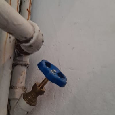 שסתום מים עם ידית כחולה על צינור