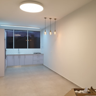 מטבח חדש עם ארונות לבנים ותאורה מודרנית