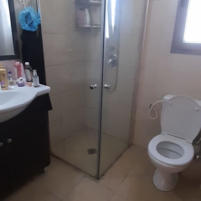 מקלחון זכוכית עם דלתות מתכת בחדר אמבטיה