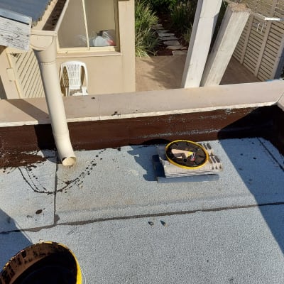 גג עם יריעות איטום, צינור ניקוז ודלי צבע