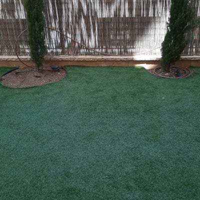 דשא סינתטי עם עצים קטנים וצינורות השקיה