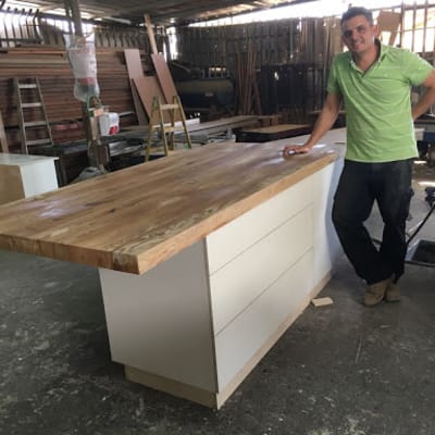 אי מטבח מעץ עם מגירות לבנות בסדנה