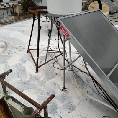 איטום גג עם חומר לבן סביב דודי שמש