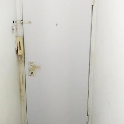 דלת לבנה עם ידית ומנעול, טלפון קיר בצד