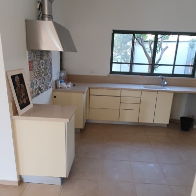 מטבח עם כיור, ברז ודלי שחור בפינה