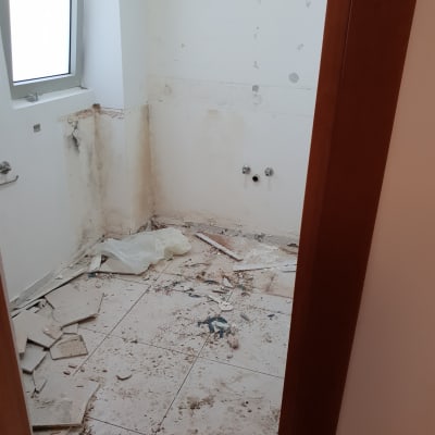 חדר עם רצפה שבורה ופסולת בנייה