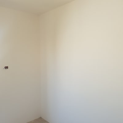 קיר צבוע בלבן עם שקע חשמלי חשוף