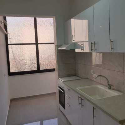 מטבח עם ארונות לבנים, כיור וברז כסופים