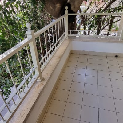 מרפסת עם מעקה מתכת לבן ורצפת אריחים