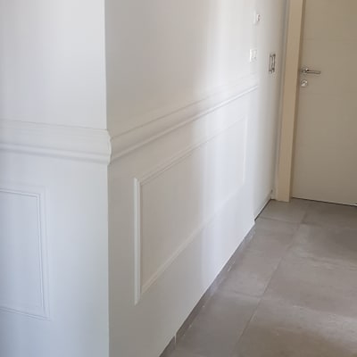 קיר צבוע בלבן עם פנלים דקורטיביים