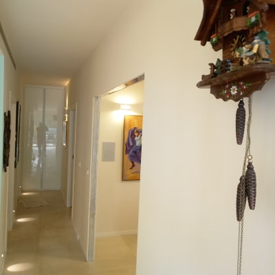 שעון קוקייה תלוי על קיר גבס במסדרון מואר