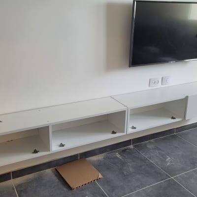 ארון לבן מותקן על קיר עם טלוויזיה תלויה