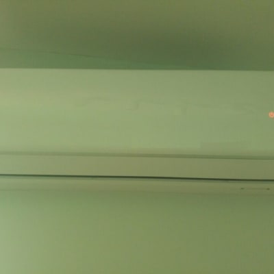 מזגן קיר לבן עם נורית חיווי דולקת