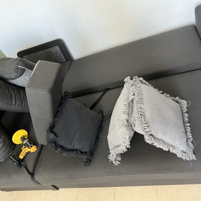 ספה אפורה עם כריות וכלי ניקוי צהוב