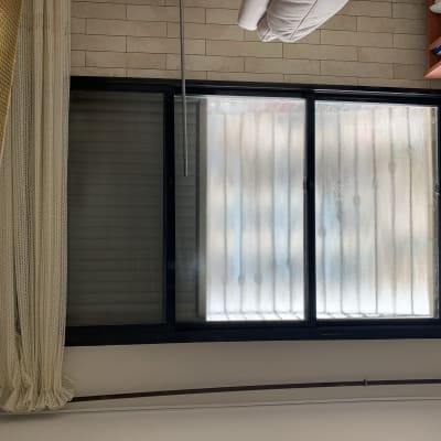 חלון זכוכית עם מסגרת שחורה ווילון בצד