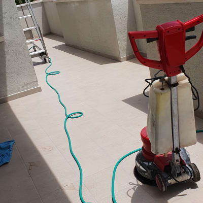 מכונת ניקוי אדומה וצינור ירוק על רצפה