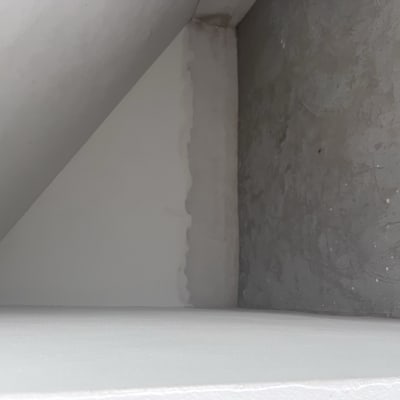 קיר צבוע חלקית עם סימני צבע אפור ולבן