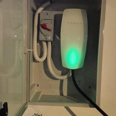 מטען טסלה עם כבל חשמלי ותיבת חיבורים