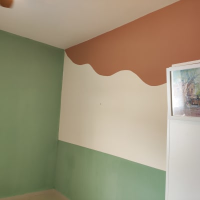 קיר צבוע בירוק, לבן וכתום עם תמונה ממוסגרת