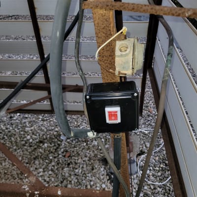 מתג חשמלי עם כבלים מחוברים על עמוד מתכת