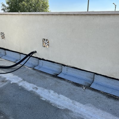 יריעות איטום כחולות על גג עם צינורות שחורים