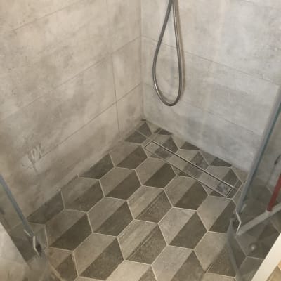 מקלחון עם אריחים גיאומטריים ודלת זכוכית