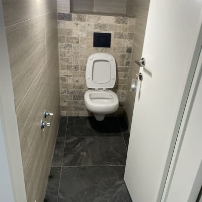 אסלה נקייה בחדר שירותים עם קירות אריחים