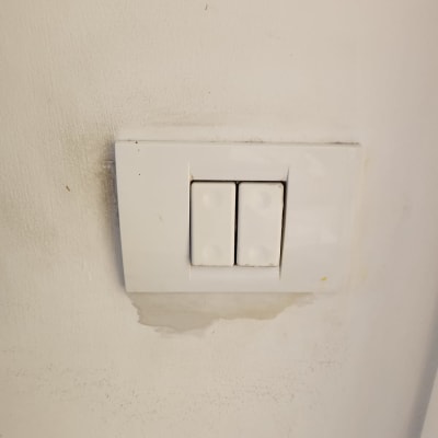 מתג חשמל כפול על קיר לבן