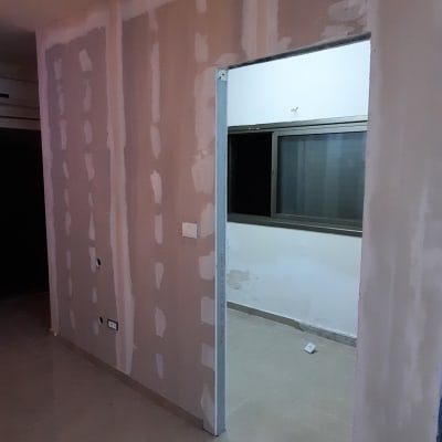 קיר גבס עם חיבורים מטויחים ופתח דלת