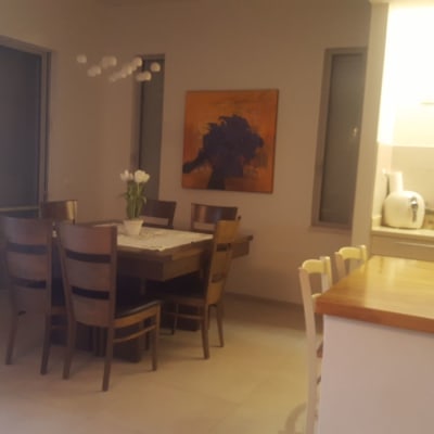 ציור מופשט בצבעים כתום וסגול על הקיר