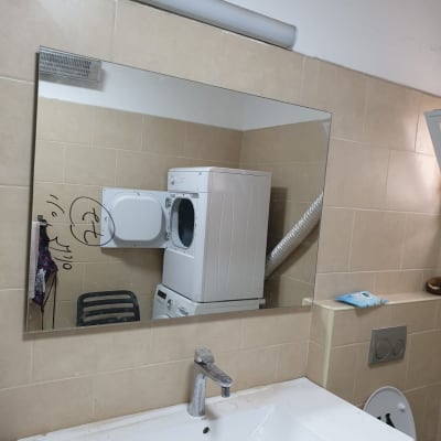 מראה גדולה על קיר חדר אמבטיה