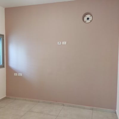 קיר צבוע בגוון ורוד בהיר עם שקעי חשמל